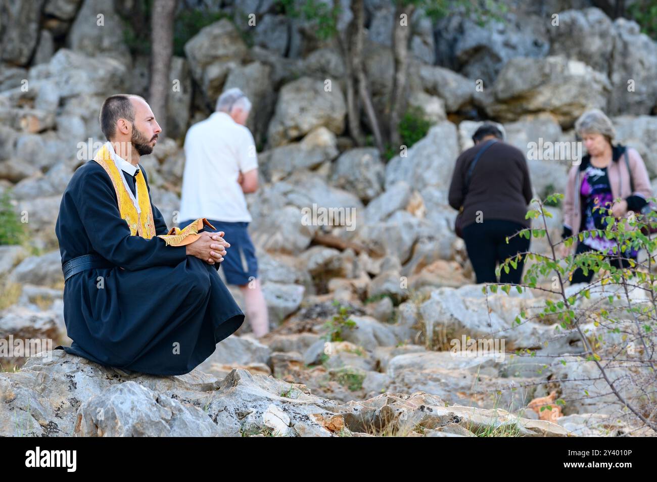 Un sacerdote greco-cattolico che prega sul Monte Podbrdo, la collina dell'apparizione che si affaccia sul villaggio di Medjugorje in Bosnia ed Erzegovina. Foto Stock