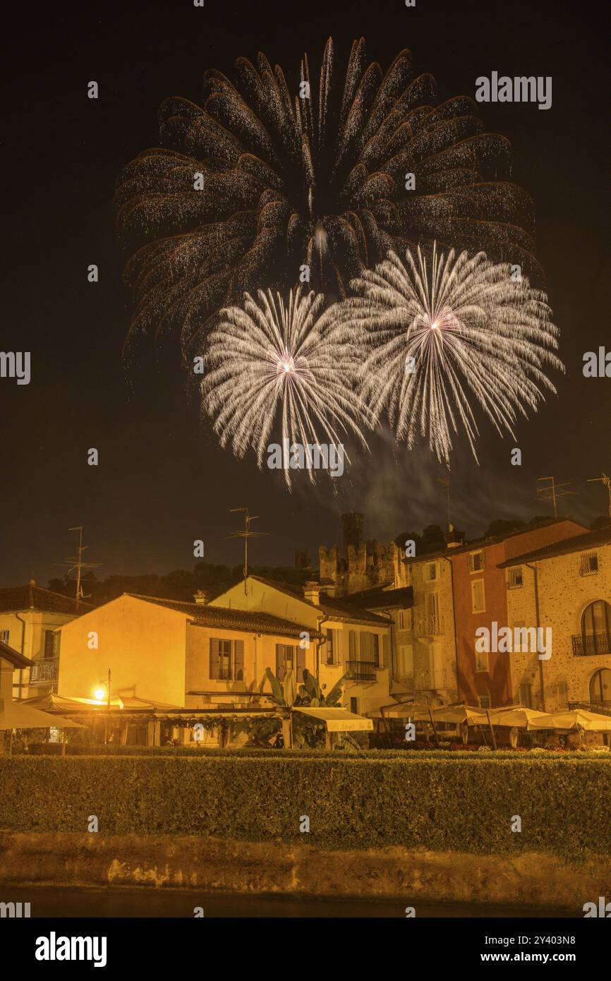 Fuochi d'artificio dal castello scaligero nelle case in primo piano di Borghetto, Valeggio sul Mincio, provincia di Verona, Italia, Europa Foto Stock