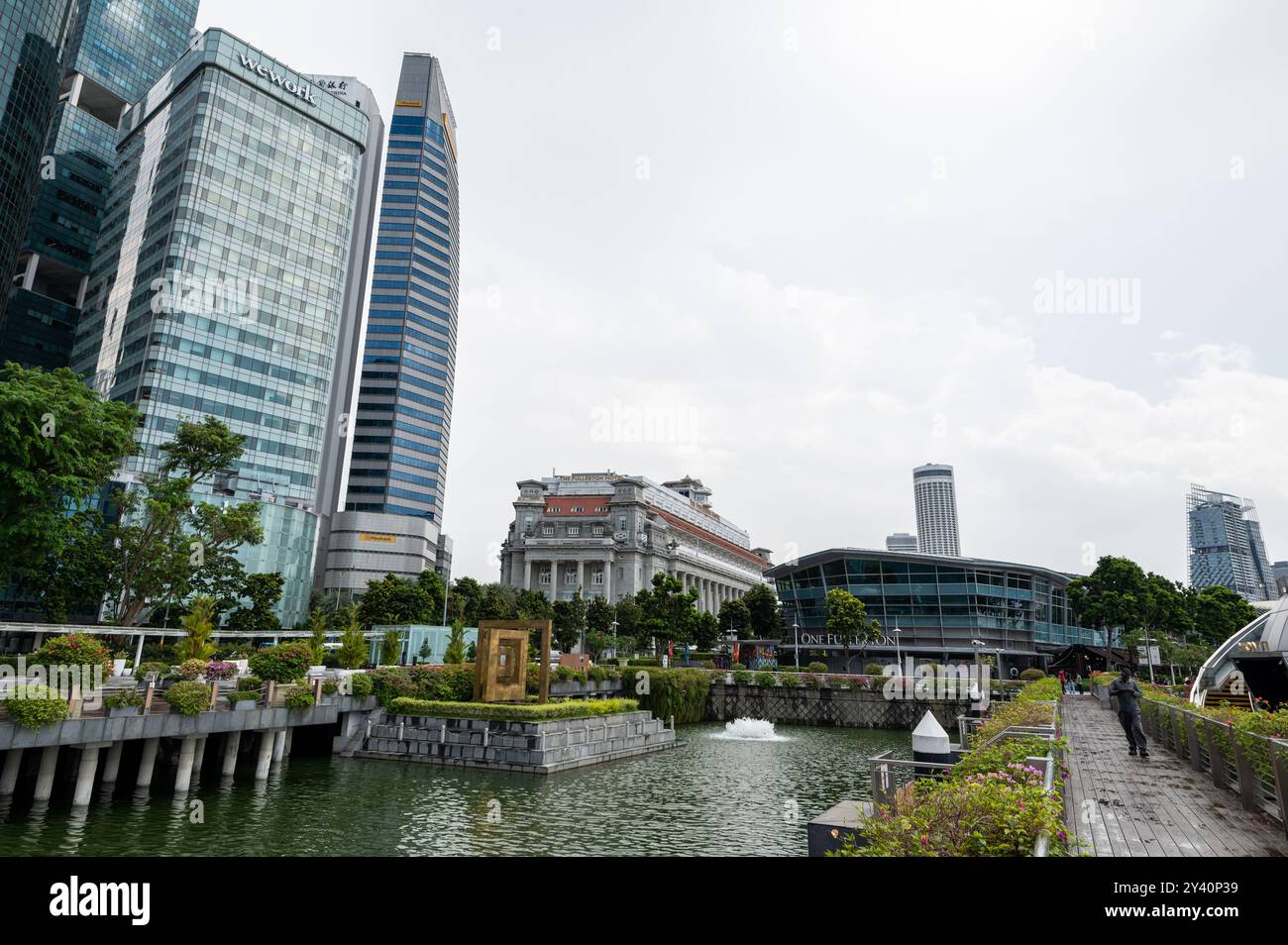 Grattacieli che torreggiano l'edificio coloniale dell'ex ufficio postale generale di Singapore, ora l'iconico Fullerton Hotel a 5 stelle a Singapore. Foto Stock