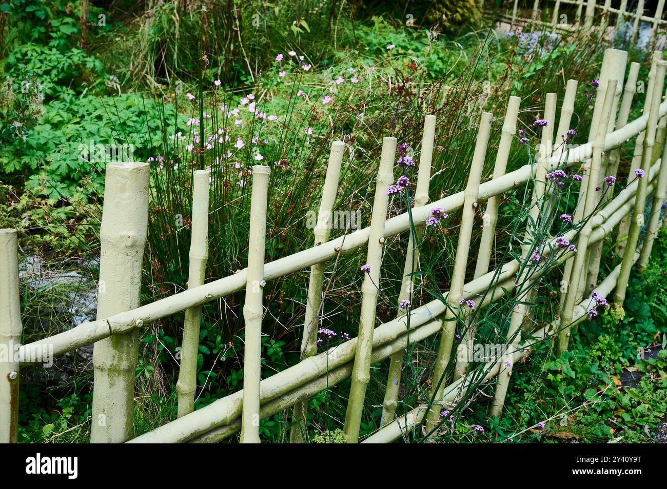 "Recinzione di bambù" metallica sul perimetro del giardino Foto Stock "Recinzione di bambù" metallica sul perimetro del giardino Foto Stock