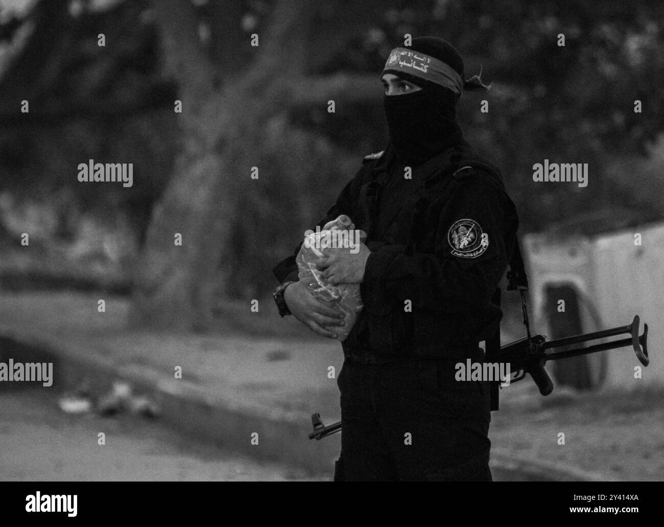 Gaza, Palestina. 12 maggio 2020. I membri delle Brigate Izz al-DIN al-Qassam, l'ala militare di Hamas, distribuiscono acqua e datteri nelle strade del quartiere Zaytoun a est della città di Gaza, prima della chiamata serale alla preghiera durante il Ramadan. I musulmani digiunano ogni giorno dall'alba al tramonto durante il mese santo del Ramadan, e rompono il loro digiuno all'ora della chiamata serale alla preghiera. Nella Striscia di Gaza, già vittima di un assedio paralizzante e di una recessione economica, le rigorose misure volte a mitigare la diffusione del COVID-19 hanno aggravato la disoccupazione, la povertà e le avverse Foto Stock