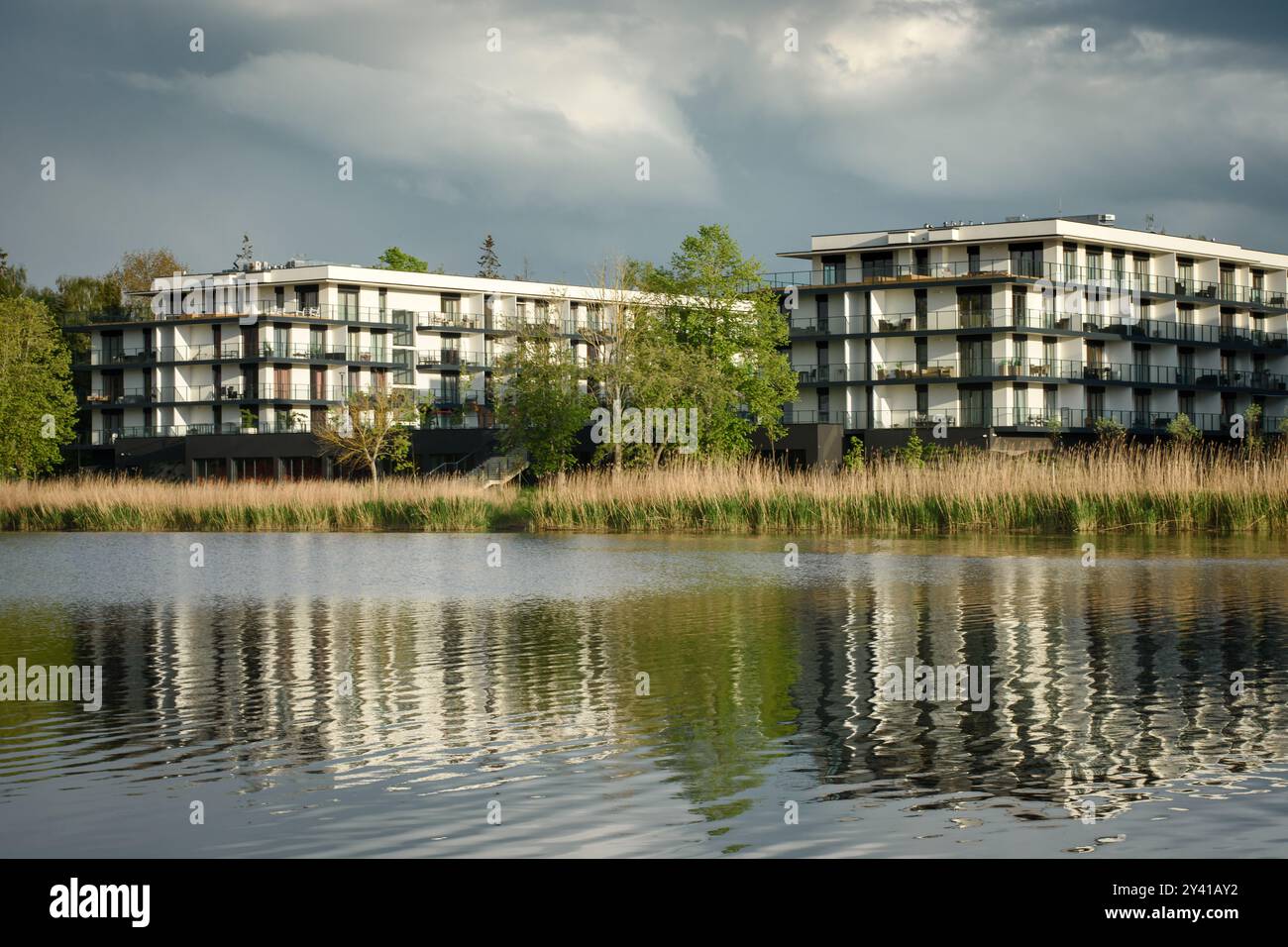 Moderne case residenziali multifamiliari situate vicino all'acqua. Giorno, cielo nuvoloso, estate, primavera Foto Stock