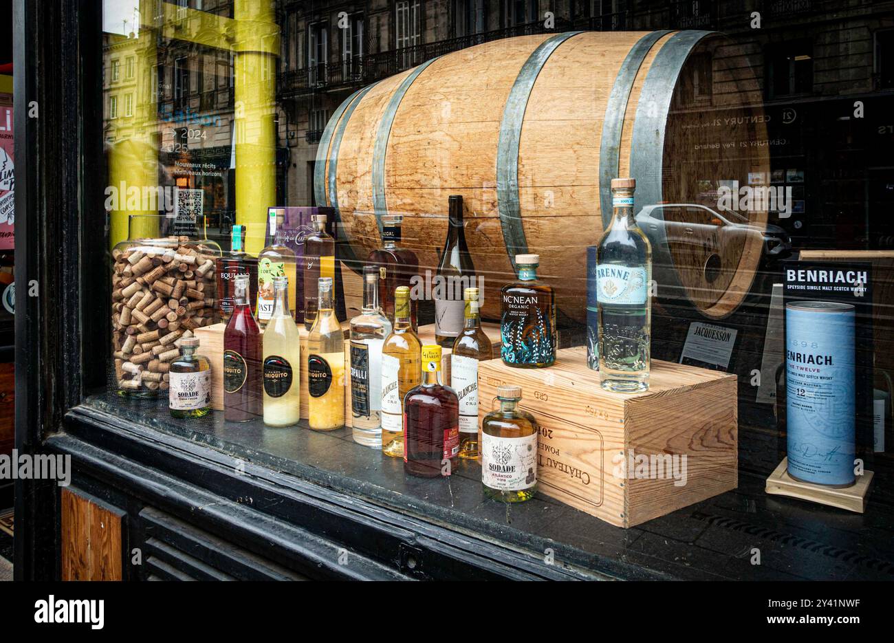 Una mostra curata mette in evidenza una serie di bottiglie di alcol, tappi e una grande botte, a Bordeaux, Francia. Foto Stock