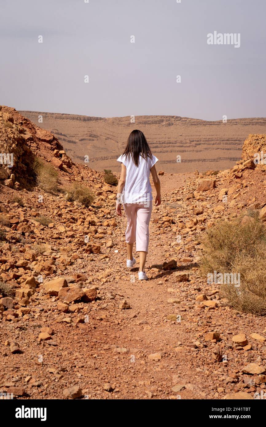Donna che cammina sul sentiero marocchino roccioso Foto Stock
