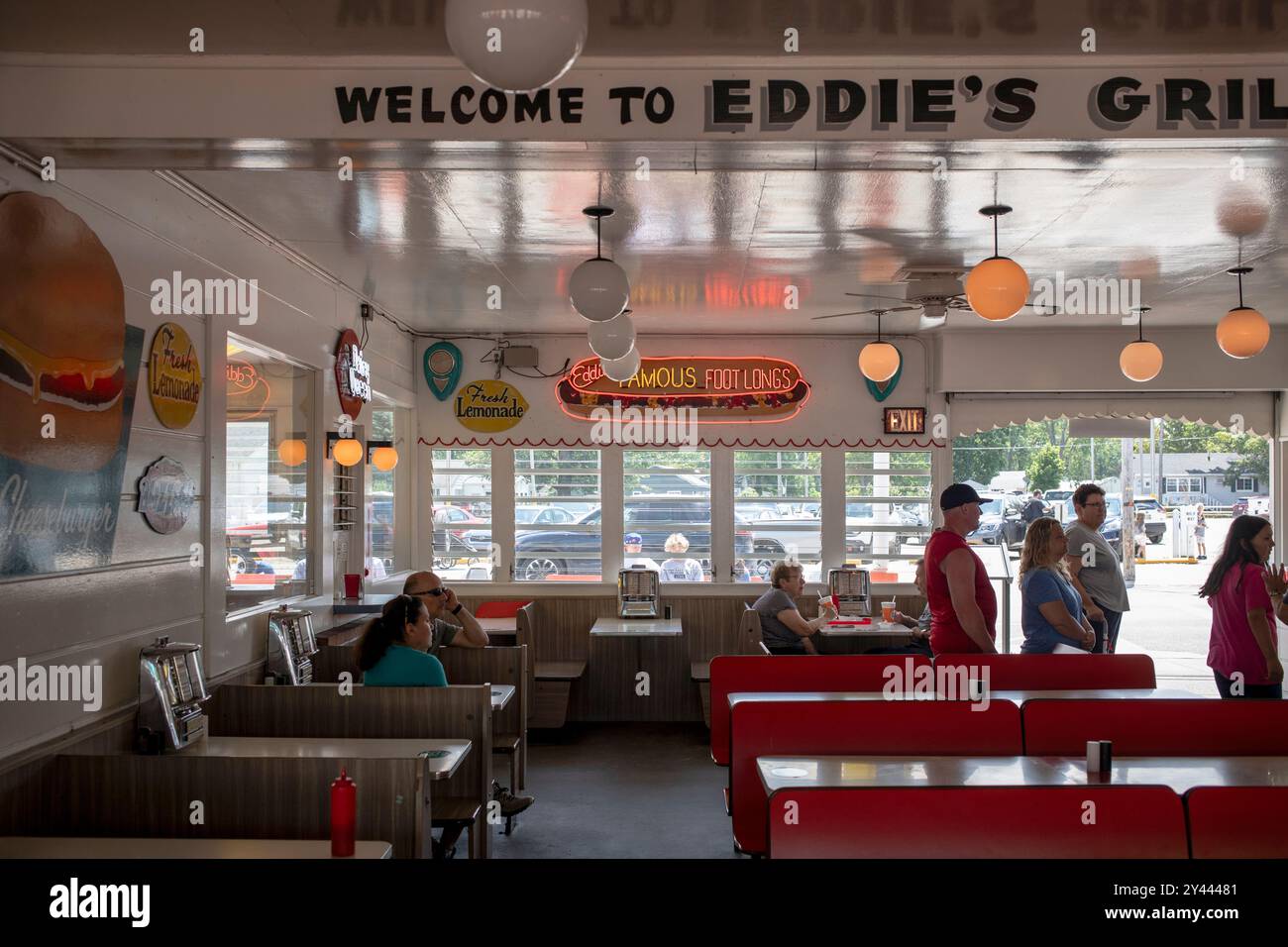 Posti a sedere interni e persone in attesa presso un ristorante sulla strada Foto Stock
