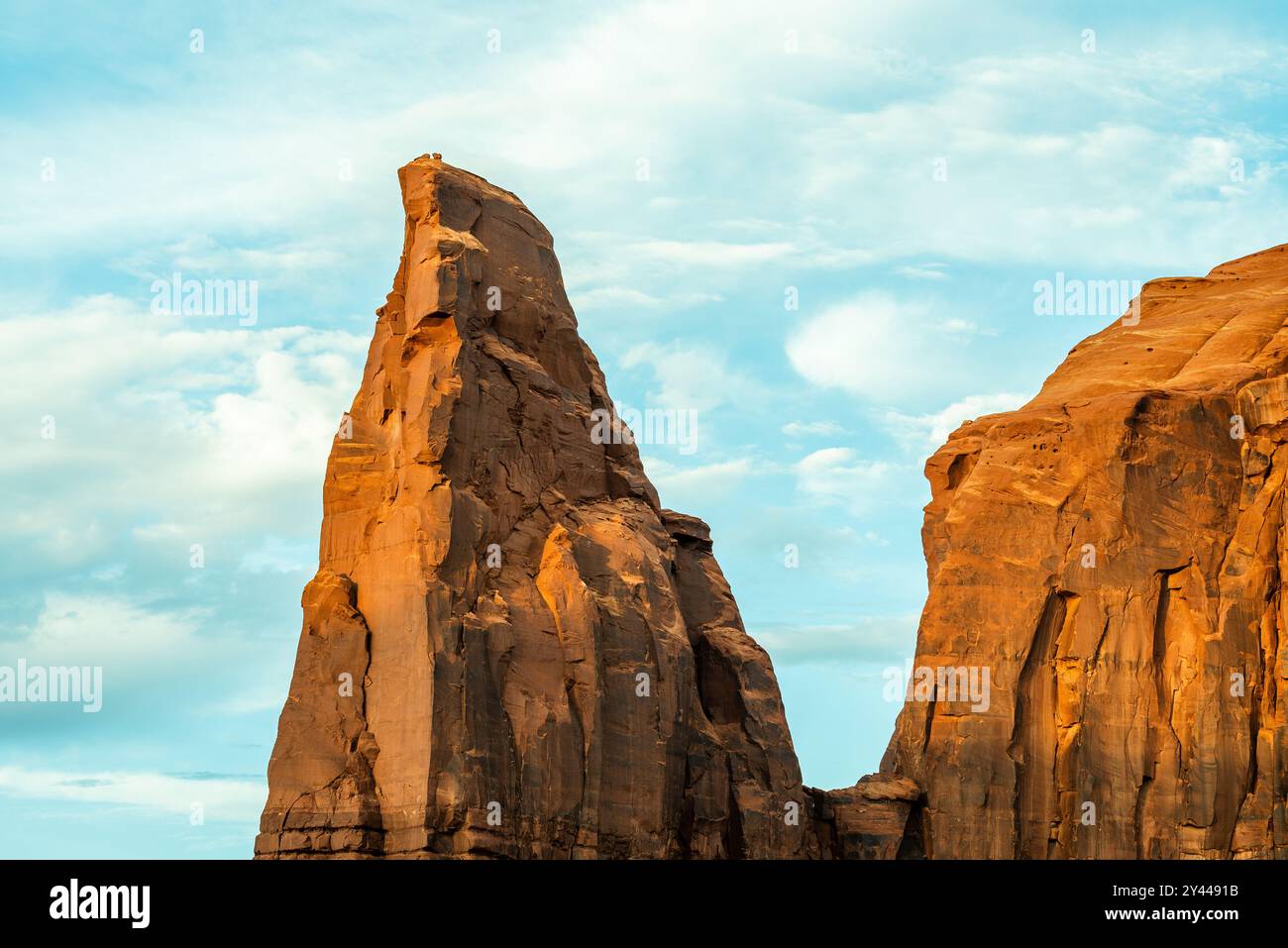 Alta vetta in arenaria contro un cielo luminoso nella Monument Valley Foto Stock