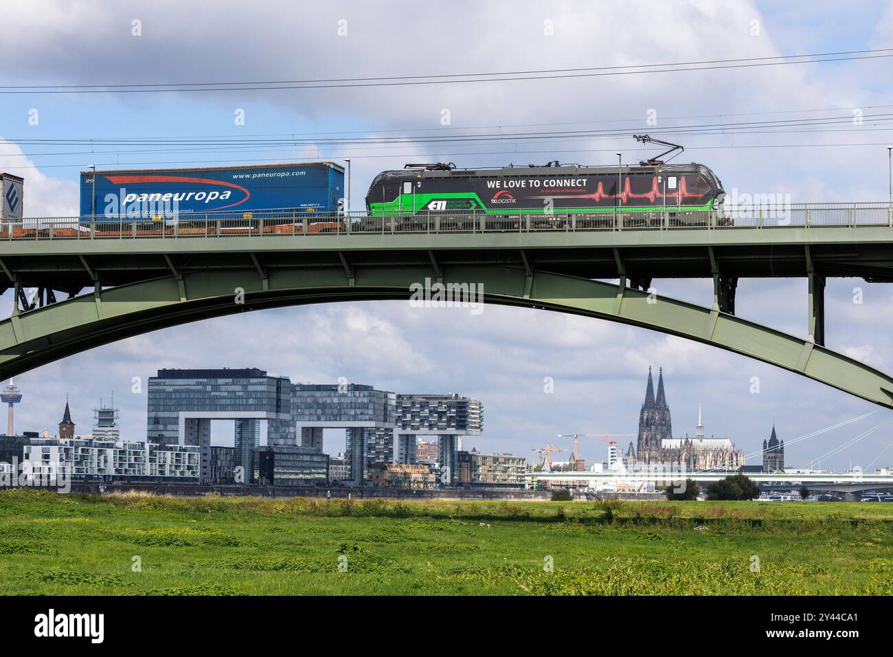 Treno merci sul Suedbruecke (ponte sud), vista sul porto di Rheinau con le Crane Houses e sulla cattedrale di Colonia, Germania. Gueterzug au Foto Stock