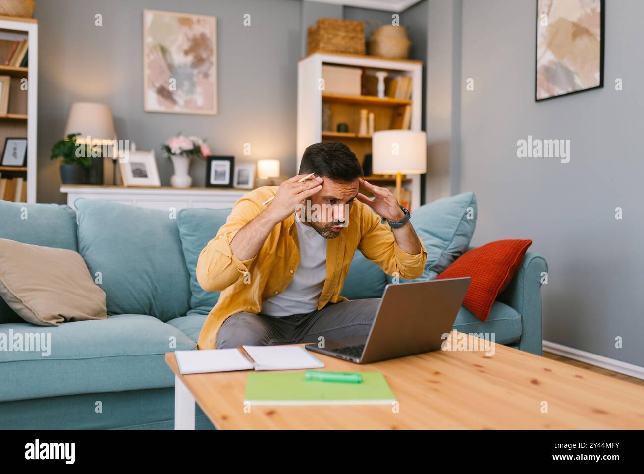 Uomo stressato che ha a che fare con un problema sul suo portatile Foto Stock