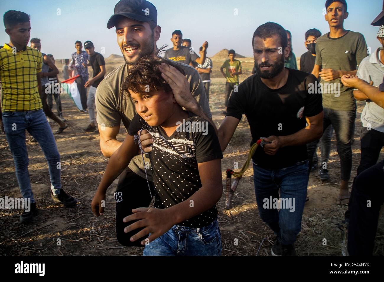 Khan Younis, Striscia di Gaza. 25 agosto 2021. Mercoledì scorso si sono verificati scontri tra le truppe israeliane e i manifestanti palestinesi nei pressi della città meridionale di Khan Younis a Gaza. I palestinesi protestarono contro il blocco di 14 anni condotto da israeliani della piccola enclave costiera quando scoppiarono scontri. Almeno cinque manifestanti palestinesi sono stati feriti da proiettili vivi e molti sono stati trattati per inalazione di gas lacrimogeni quando le forze israeliane hanno usato gas lacrimogeni e munizioni vive per disperdere i manifestanti Foto Stock