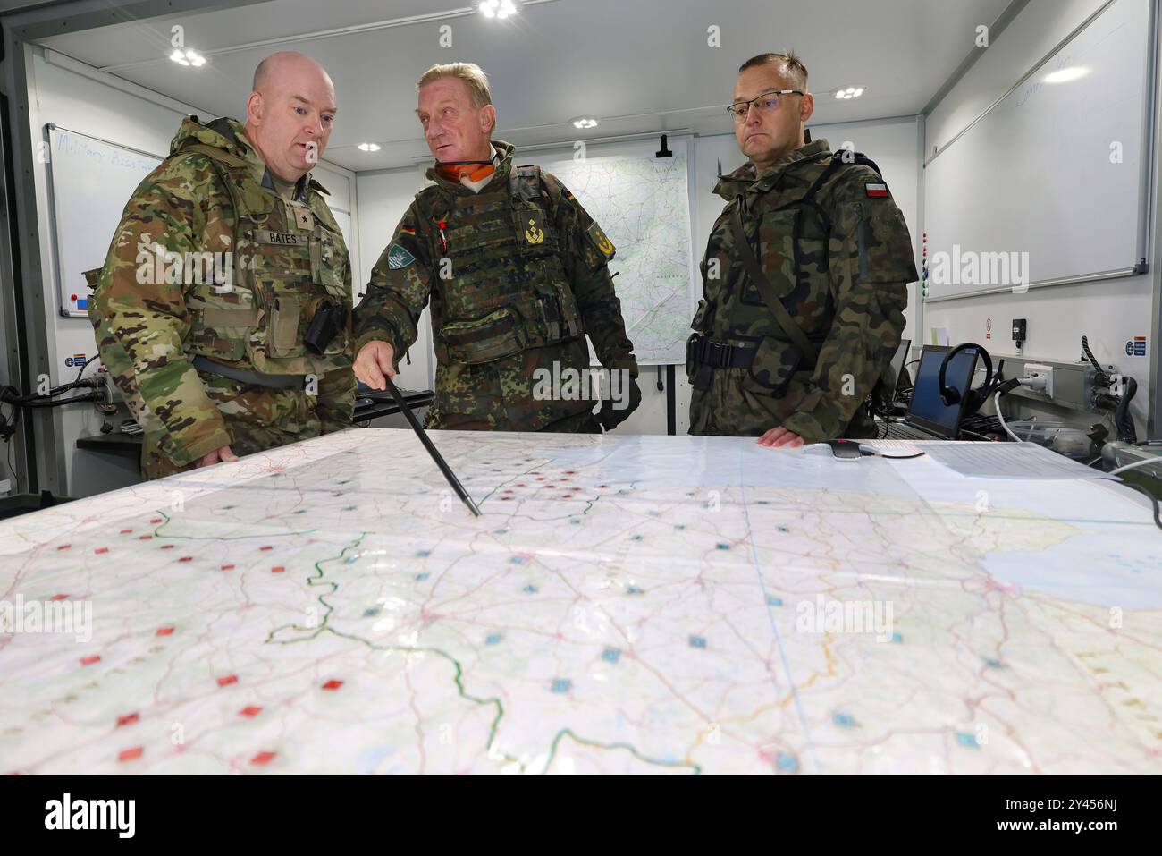 16 settembre 2024, Baviera, Kümmersbruck: Il tenente generale Jürgen-Joachim von Sandrart (M), comandante del corpo multinazionale della NATO nord-est, parla con il generale di brigata Andrew Bates (l) delle forze armate statunitensi e il generale di brigata Tomasz Kowalik (r) dell'esercito polacco nella postazione di comando mobile. Soldati provenienti da numerosi paesi della NATO - tra cui Estonia, Francia, Germania, Gran Bretagna, Italia, Lettonia, Lituania, Paesi Bassi, Polonia, Spagna e Stati Uniti - partecipano all'esercitazione del posto di comando NATO Avenger Triad 24. L'esercitazione si svolgerà dal 9 al 19 settembre in varie località Foto Stock