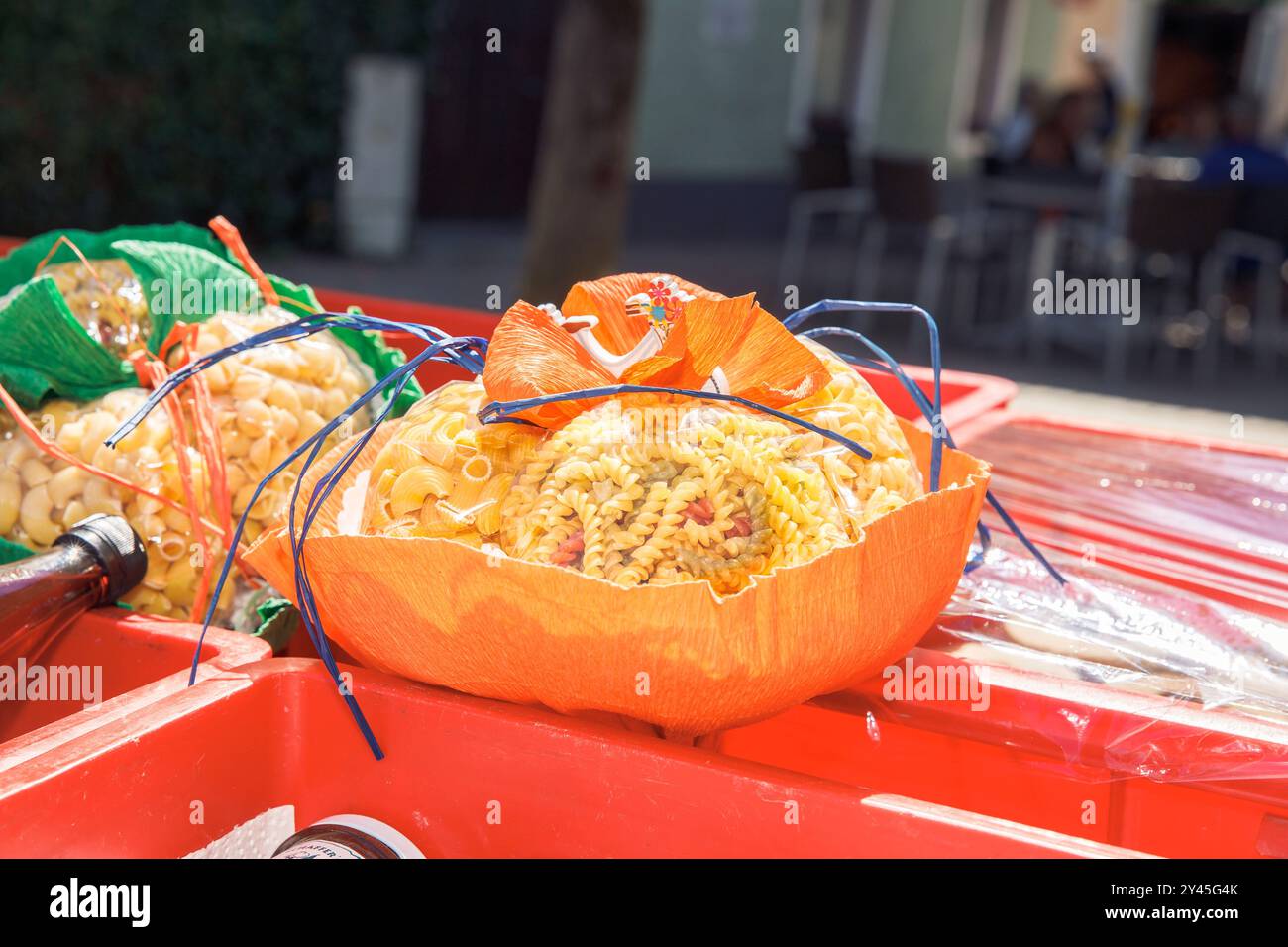 Disposizione della pasta illuminata dal sole nel cestino decorativo per il mercato all'aperto, esposizione di pasta colorata, concetto di arte culinaria Foto Stock