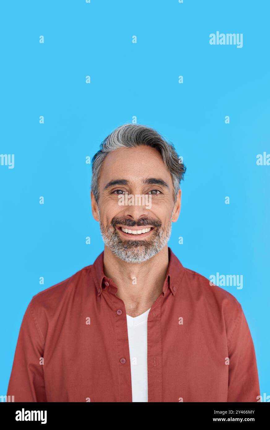 Uomo felice, maturo e informale, isolato su sfondo blu. Verticale. Foto Stock