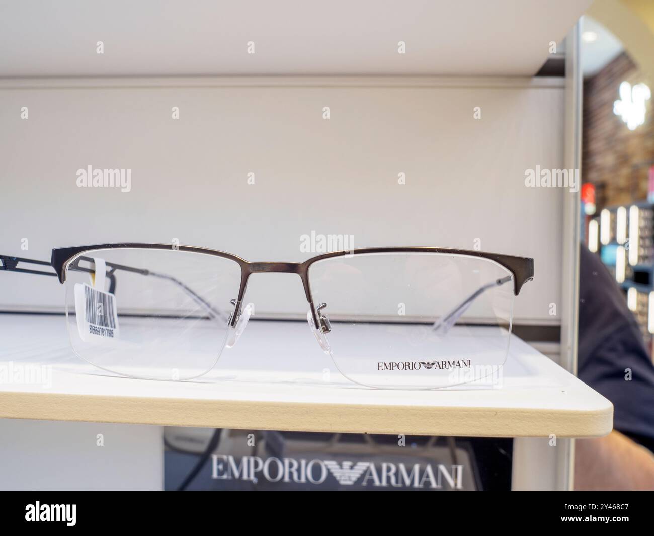 Gli eleganti occhiali da vista emporio armani sono esposti su un espositore, sottolineando la presenza del marchio nell'ambiente di vendita ottica Foto Stock