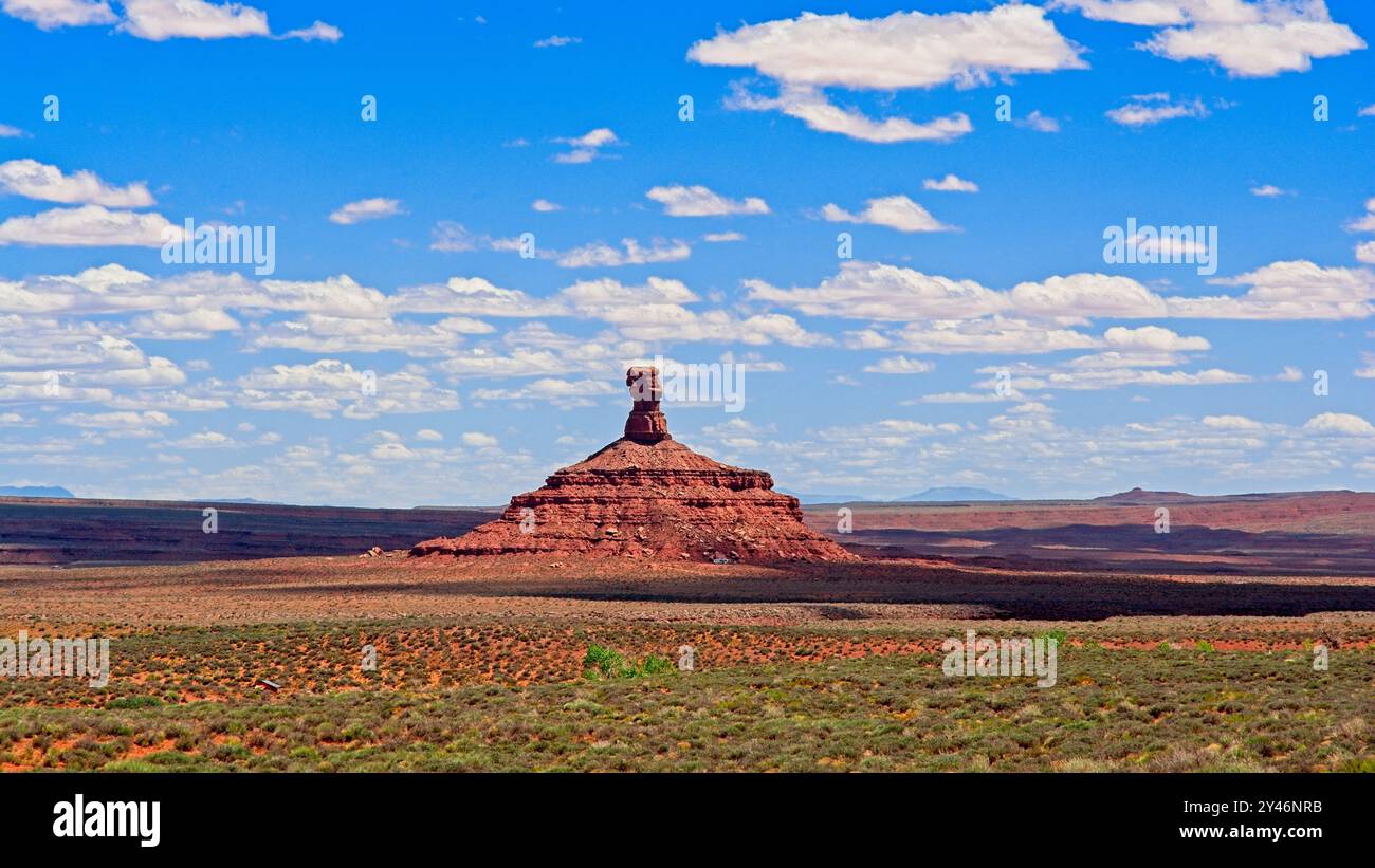 Le ombre proiettate dalle nuvole incorniciano l'imponente Rooster Butte sul fondovalle della Valle degli dei dello Utah Foto Stock