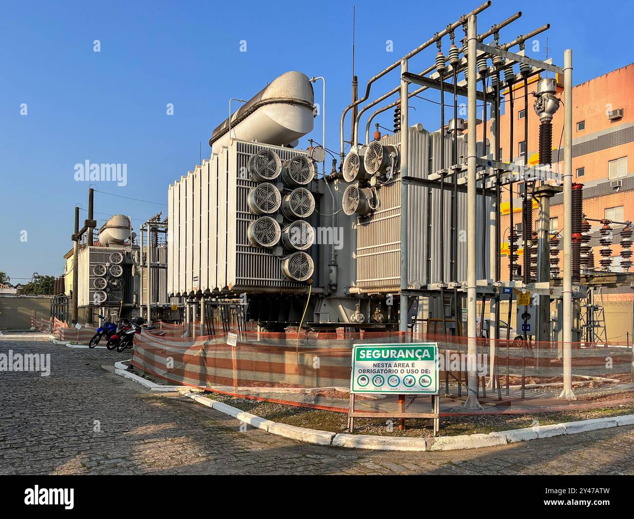 Sottocentrale elettrica nella città di Santos, Brasile. Segnale di avvertenza di sicurezza con simboli: "Sicurezza: L'uso di attrezzature di sicurezza è obbligatorio in quest'area". Foto Stock