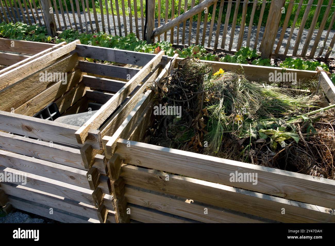 Compostatori in legno per rifiuti da giardino che saranno riciclati in compost e pacciamatura per aiuole e orti Foto Stock