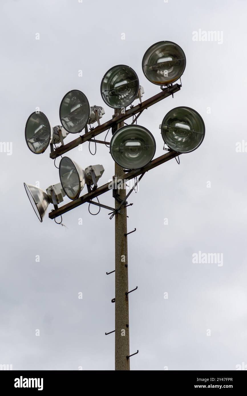 Lo stadio all'aperto è illuminato da luci e si staglia su uno sfondo bianco del cielo. Scatto verticale. Foto Stock