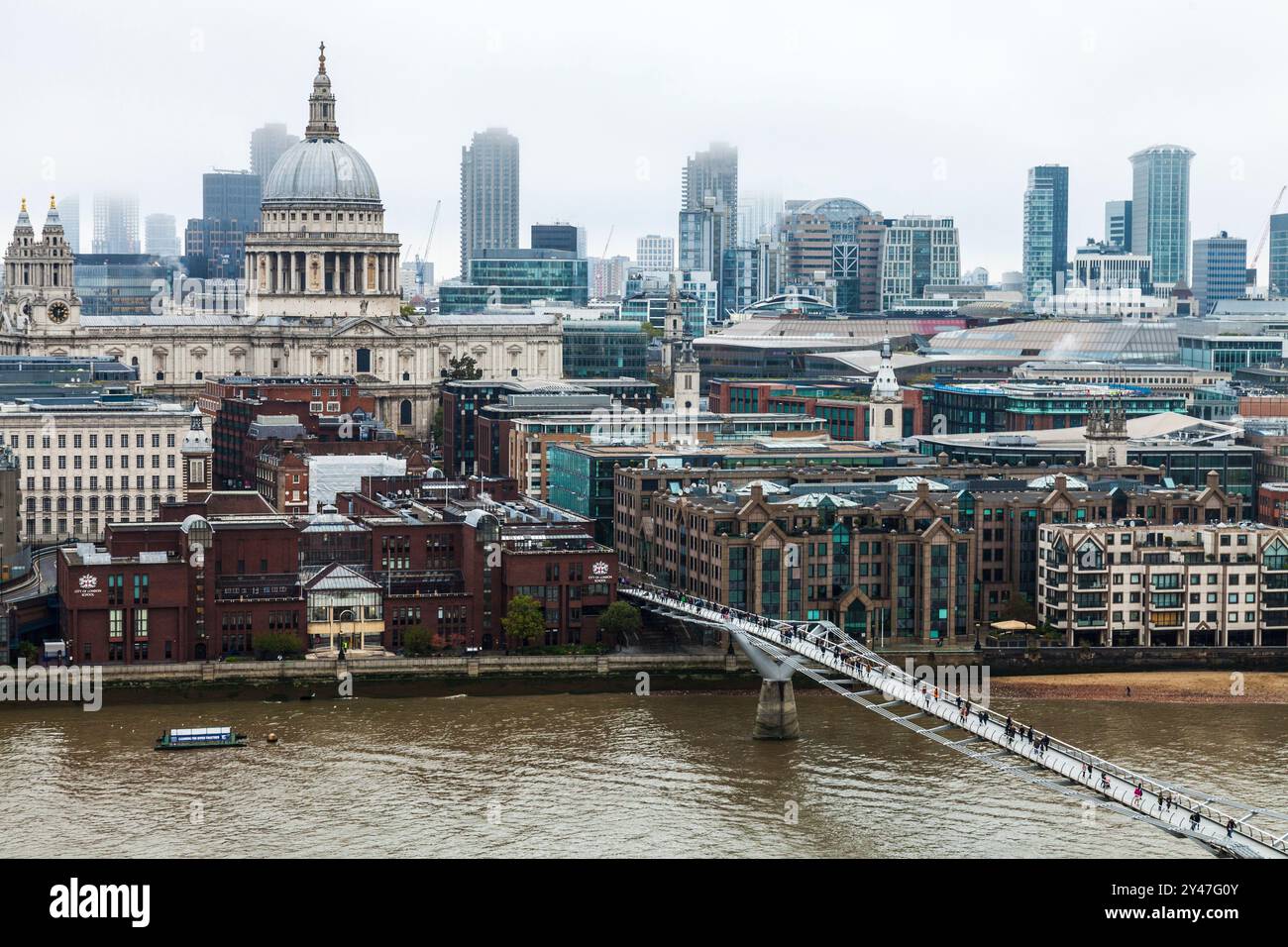 Una vista lungo il Millenium Bridge fino a St Paul's Cathedral a Londra, Inghilterra, Regno Unito. Giornata Foggy sul Tamigi. Foto Stock