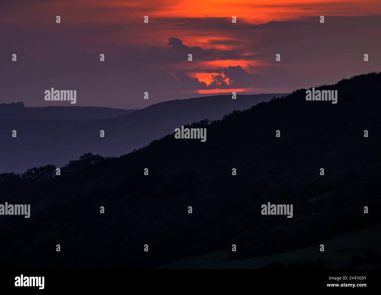 Sole rosso e tramonto a Mendips, preso da Deer Leap, il punto più alto di Mendips, Somerset, regno unito al tramonto, con strati di colline Foto Stock
