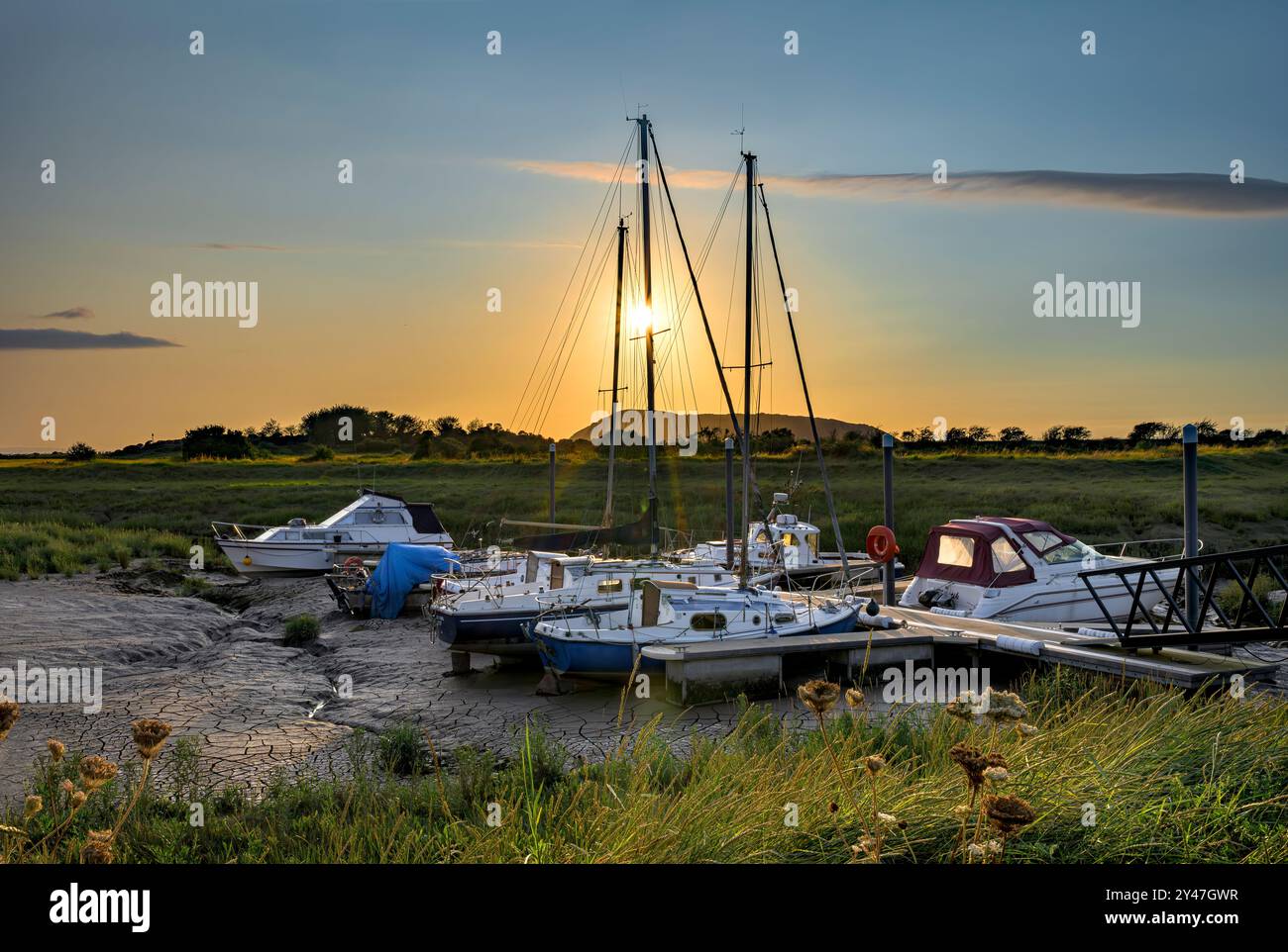 Barche nel letto essiccato del fiume exe Estuary a Uphill, Weston-Super-Mare, Regno Unito durante le estati serali nell'ora d'oro Foto Stock