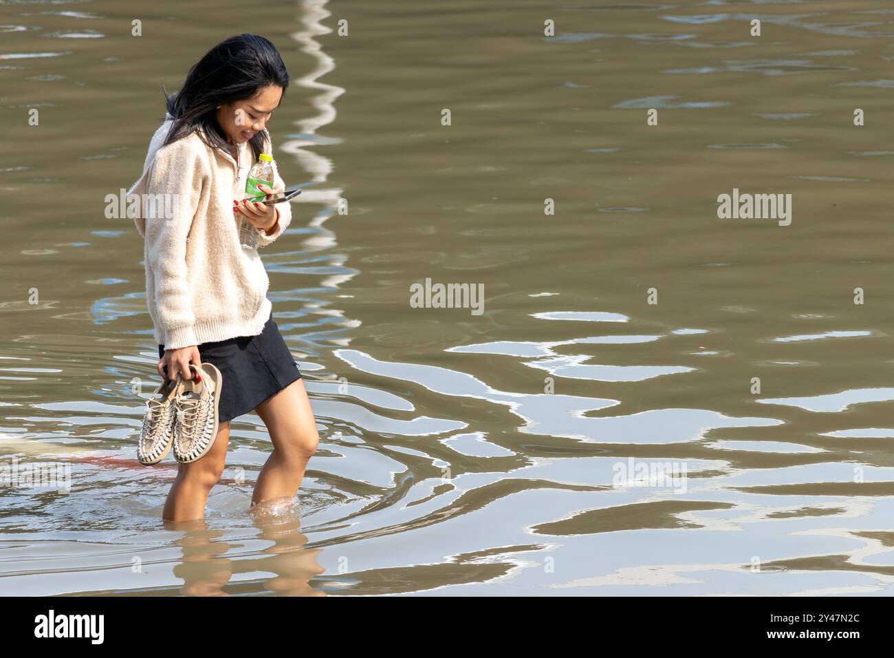 SAMUT PRAKAN, TAILANDIA, febbraio 02 2024, Una donna cammina attraverso una strada allagata Foto Stock