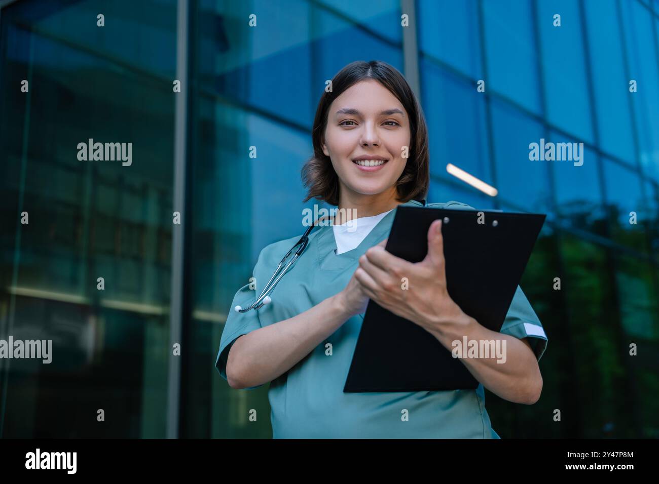 Gravidanza sorridente giovane medico con un elenco di prescrizioni in mano Foto Stock