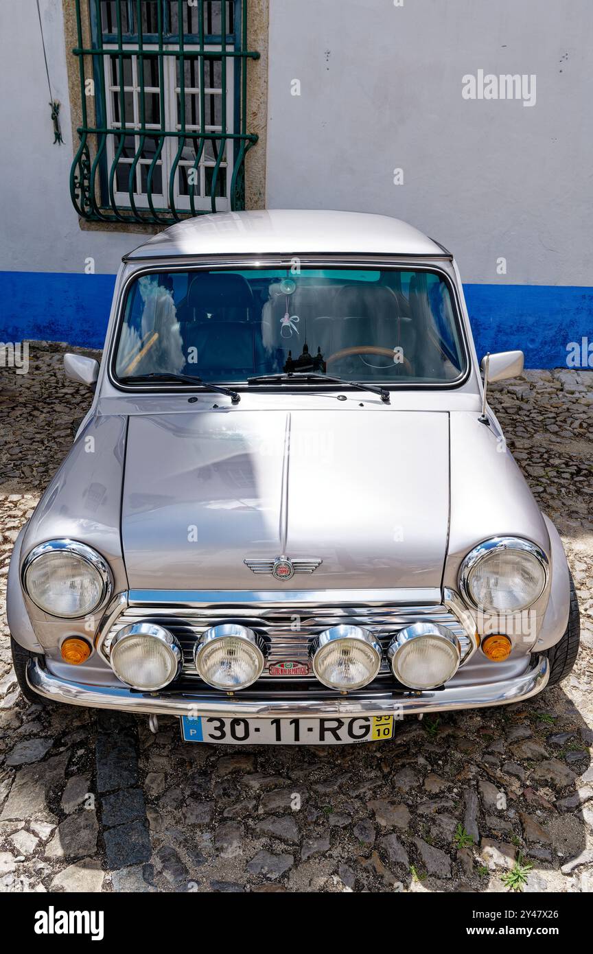 Mini classico parcheggiato su strade acciottolate nell'affascinante cittadina di Obidos Foto Stock