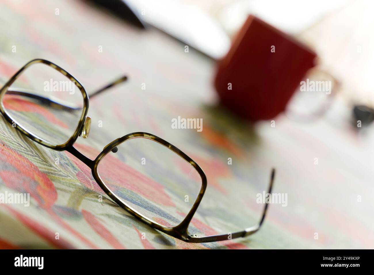 Un paio di bicchieri si siede su un tavolo accanto a una tazza da caffè rossa. Concetto di relax e svago Foto Stock