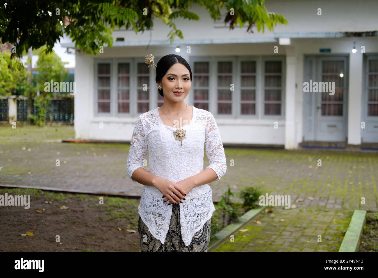 Una giovane donna indonesiana con una felice espressione di successo che indossa un kebaya bianco. Kartini's Day. Foto Stock