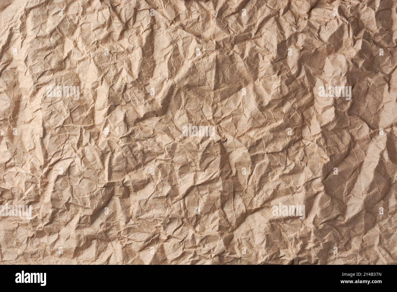 superficie di carta marrone sgualcita, foglio di carta ruvido in tonalità brunastra sfondo o trama dello sfondo, spazio di copia per il testo Foto Stock
