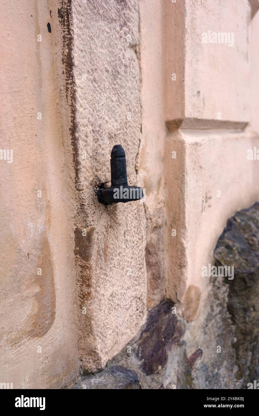 Primo piano di una cerniera metallica nera su un muro in pietra Foto Stock