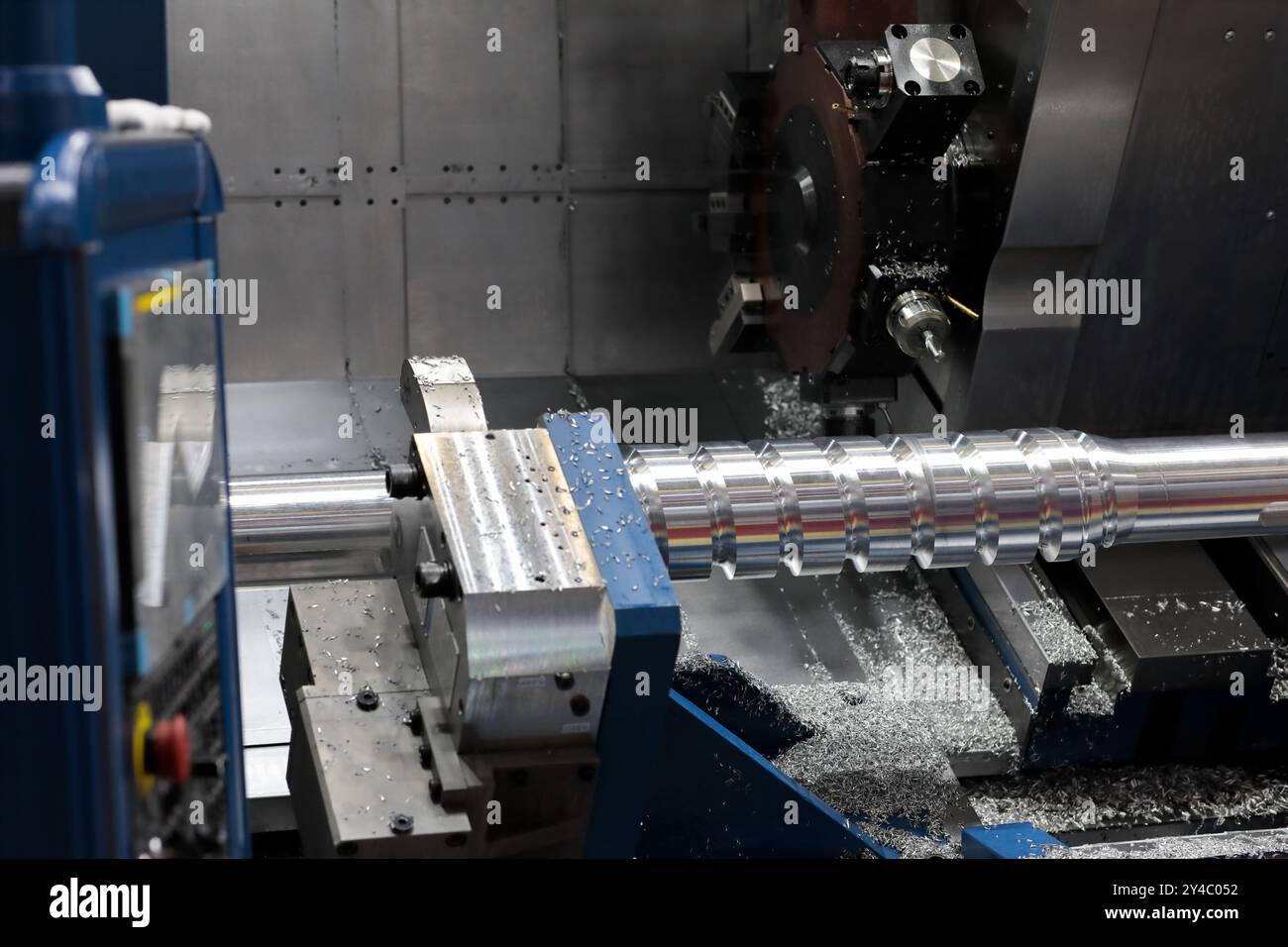 Processo di produzione della coclea su una macchina per tornitura e fresatura CNC con letto inclinato. Messa a fuoco selettiva. Foto Stock