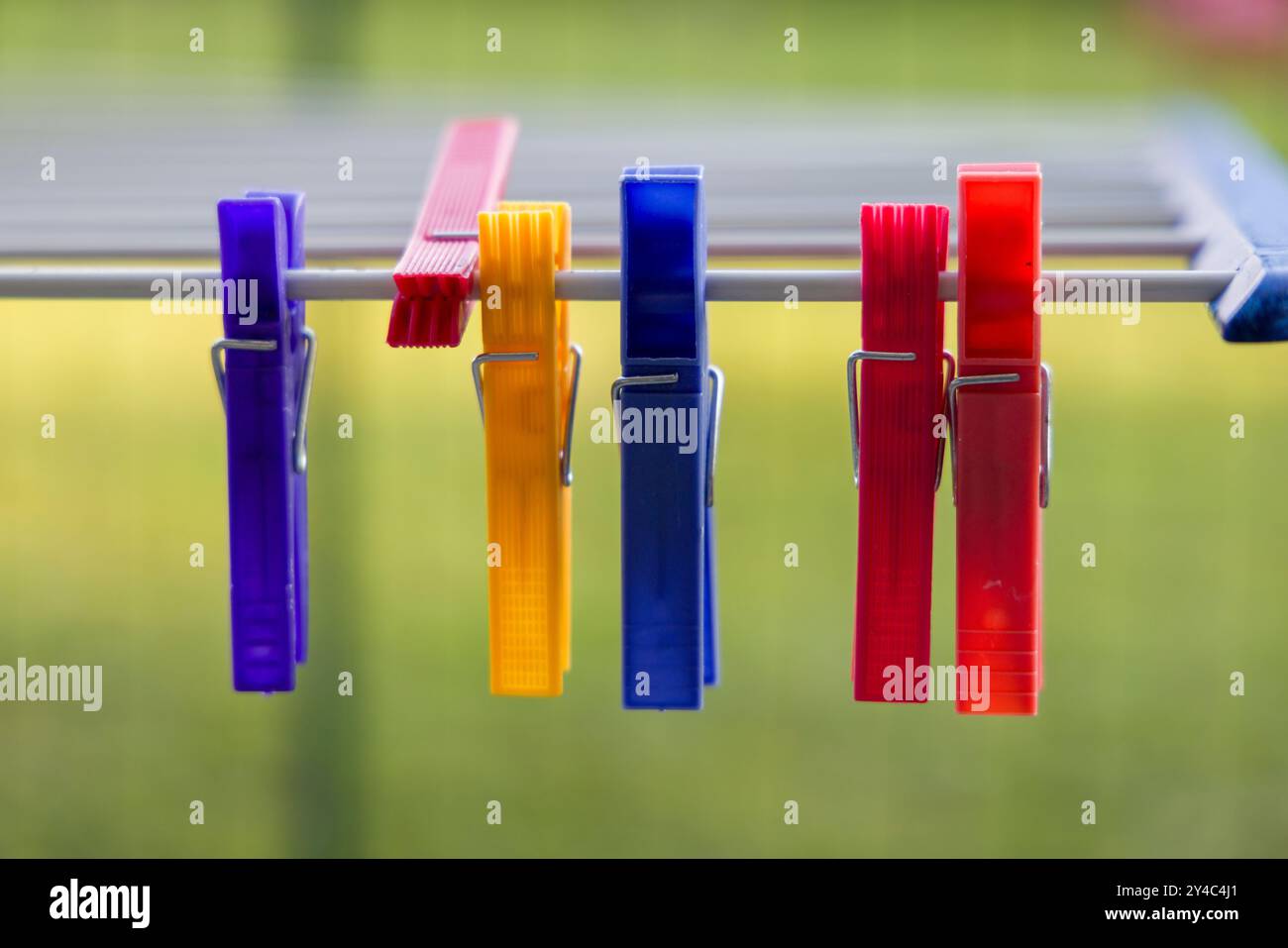 I fermagli colorati sono appesi al supporto di asciugatura Foto Stock