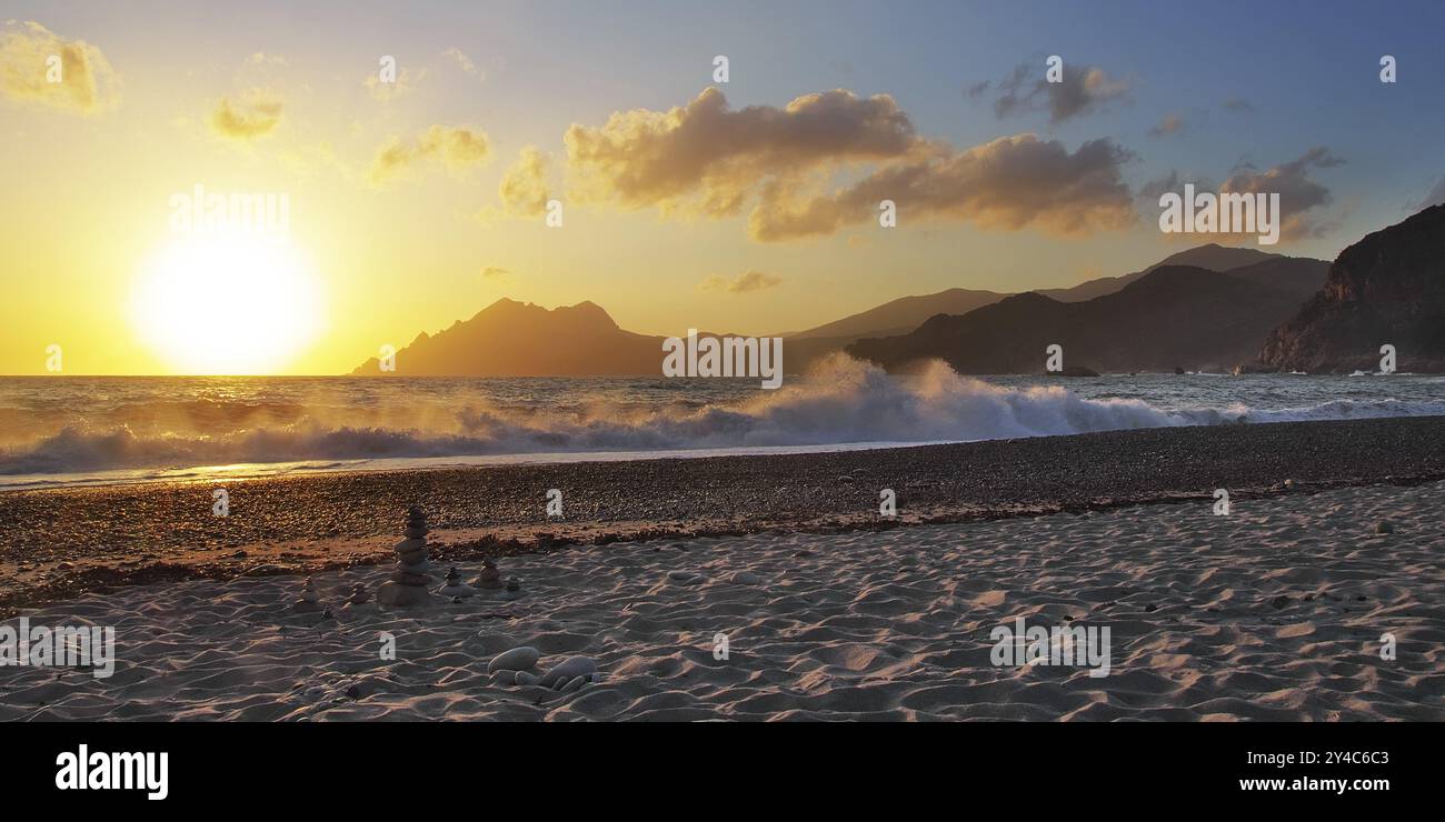 Tramonto con onde da surf sulla spiaggia di Porto, Corsica Foto Stock