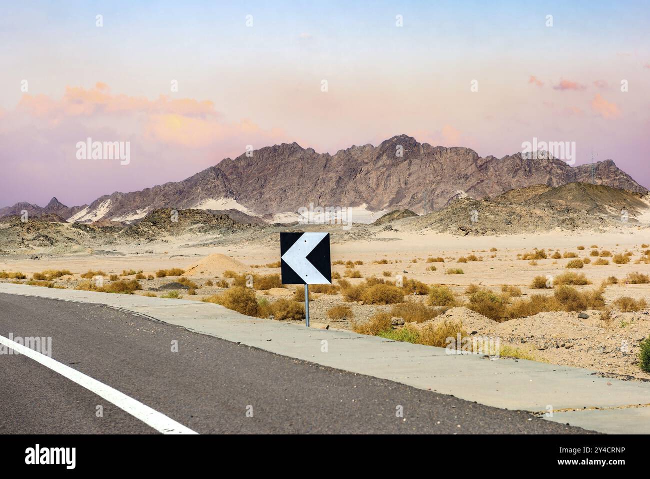 Segno sulla strada del deserto di Egitto al tramonto Foto Stock