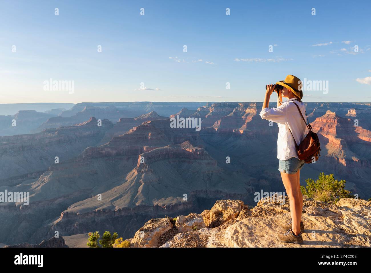 Giovane donna che guarda attraverso il binocolo gli uccelli sul canyon, zoologia, ecologia. Ricerca in natura, osservazione degli animali Foto Stock
