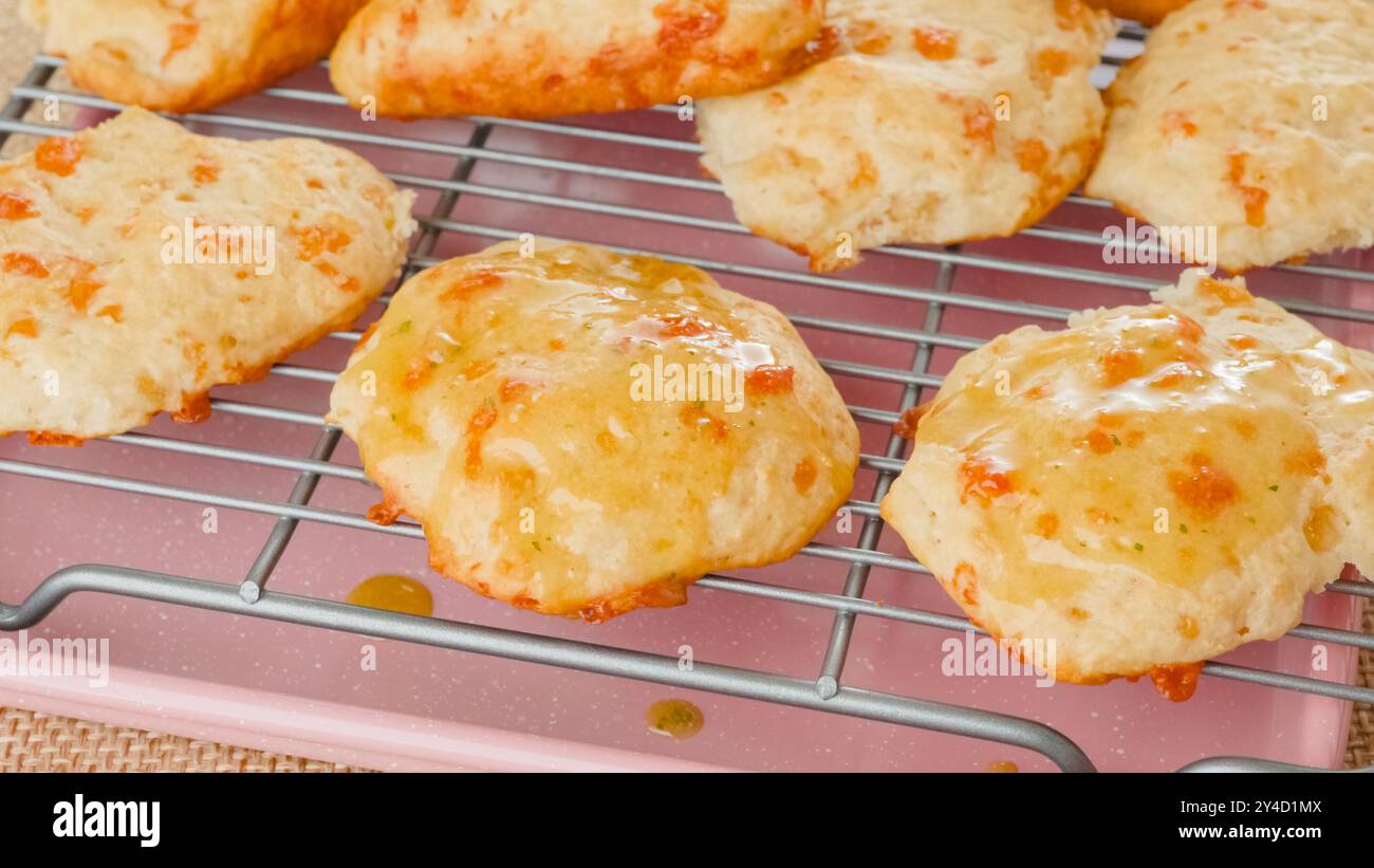 Primi piani di biscotti al formaggio appena sfornati su una griglia rinfrescante. Foto Stock