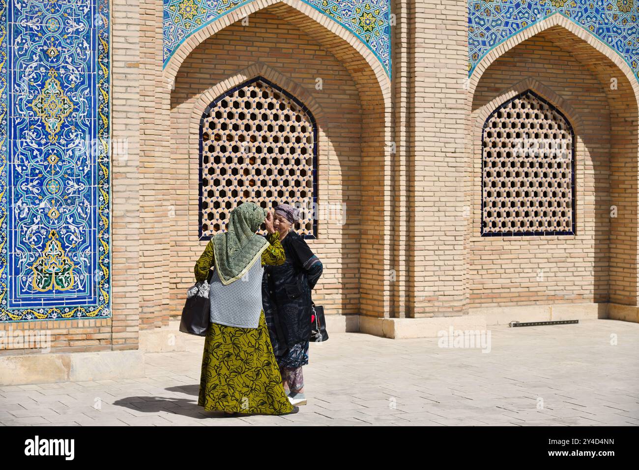 Bukhara, Uzbekistan - 13 settembre. 2024: Due donne anziane locali parlano contro il muro del Bahouddin Naqshband Memorial Complex Foto Stock