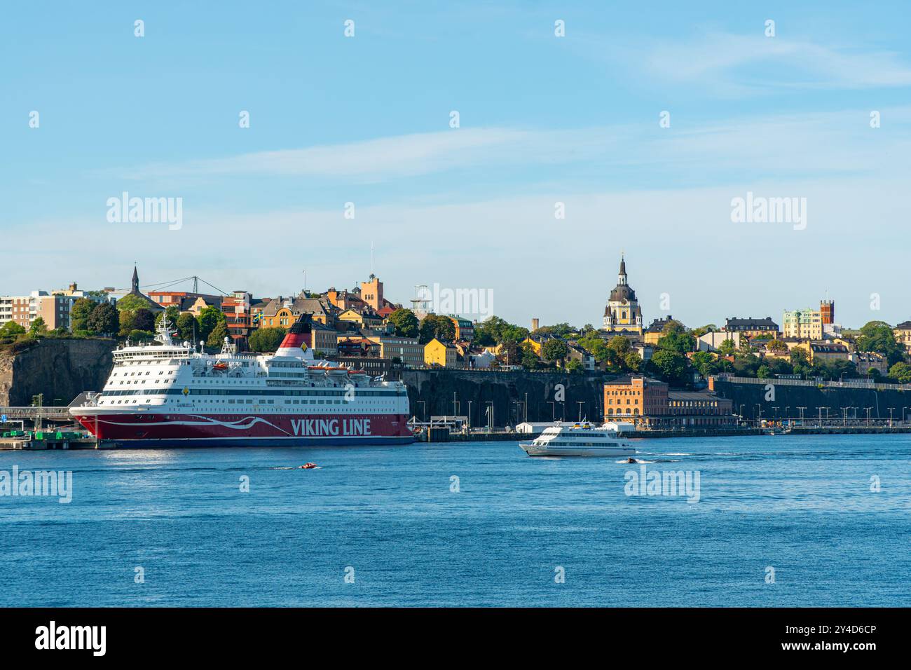 Nave da crociera della Viking Line nell'insenatura verso la città vecchia di Stoccolma, limpida giornata estiva, con un panorama della città e del suo skyline Foto Stock