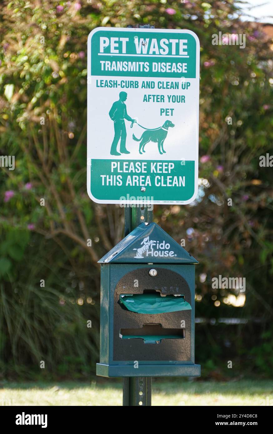Wilmington, Delaware, U.S.A - 8 settembre 2024 - il cartello verde e bianco con una scatola di plastica che offre sacchetti di plastica per i proprietari di cani da pulire dopo t Foto Stock
