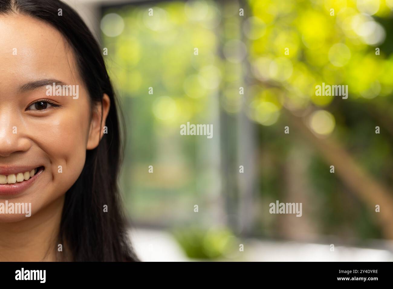Giovane donna asiatica sorridente con i capelli lunghi, godendo di una giornata luminosa e allegra, copia spazio Foto Stock