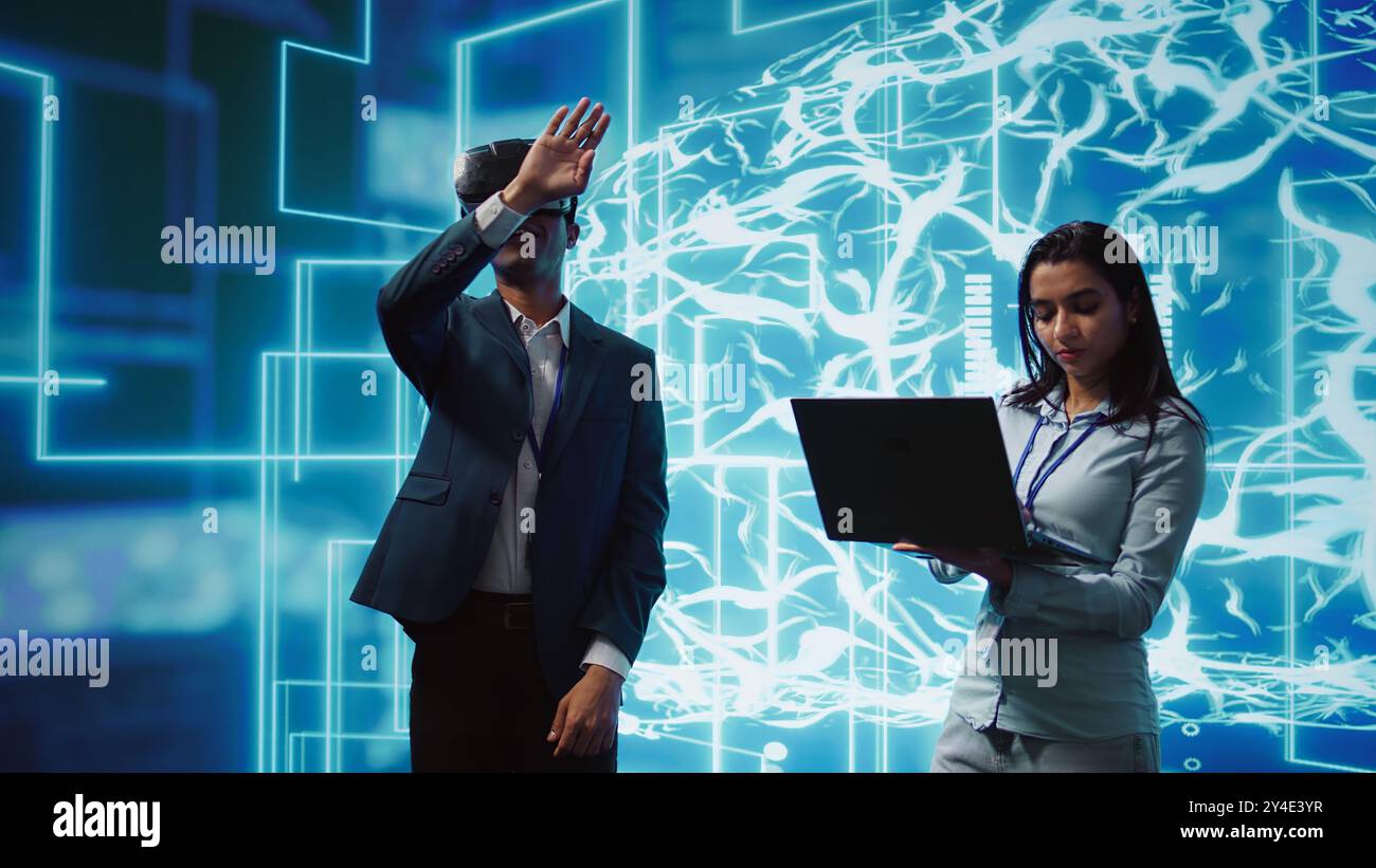 Gli ingegneri utilizzano occhiali di protezione intelligenti per la realtà virtuale e reti neurali ai per risolvere i problemi aziendali. Esperti IT che utilizzano l'intelligenza artificiale e la tecnologia di realtà virtuale AR per visualizzare i dati aziendali delle startup, telecamera B. Foto Stock