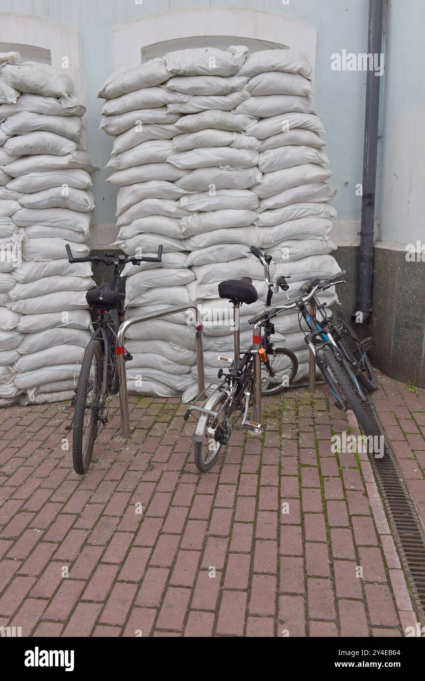 Una bicicletta si trova contro un mucchio di sacchetti che proteggono i venti contro gli attacchi aerei, Kiev, Ucraina maggio 2024 Foto Stock