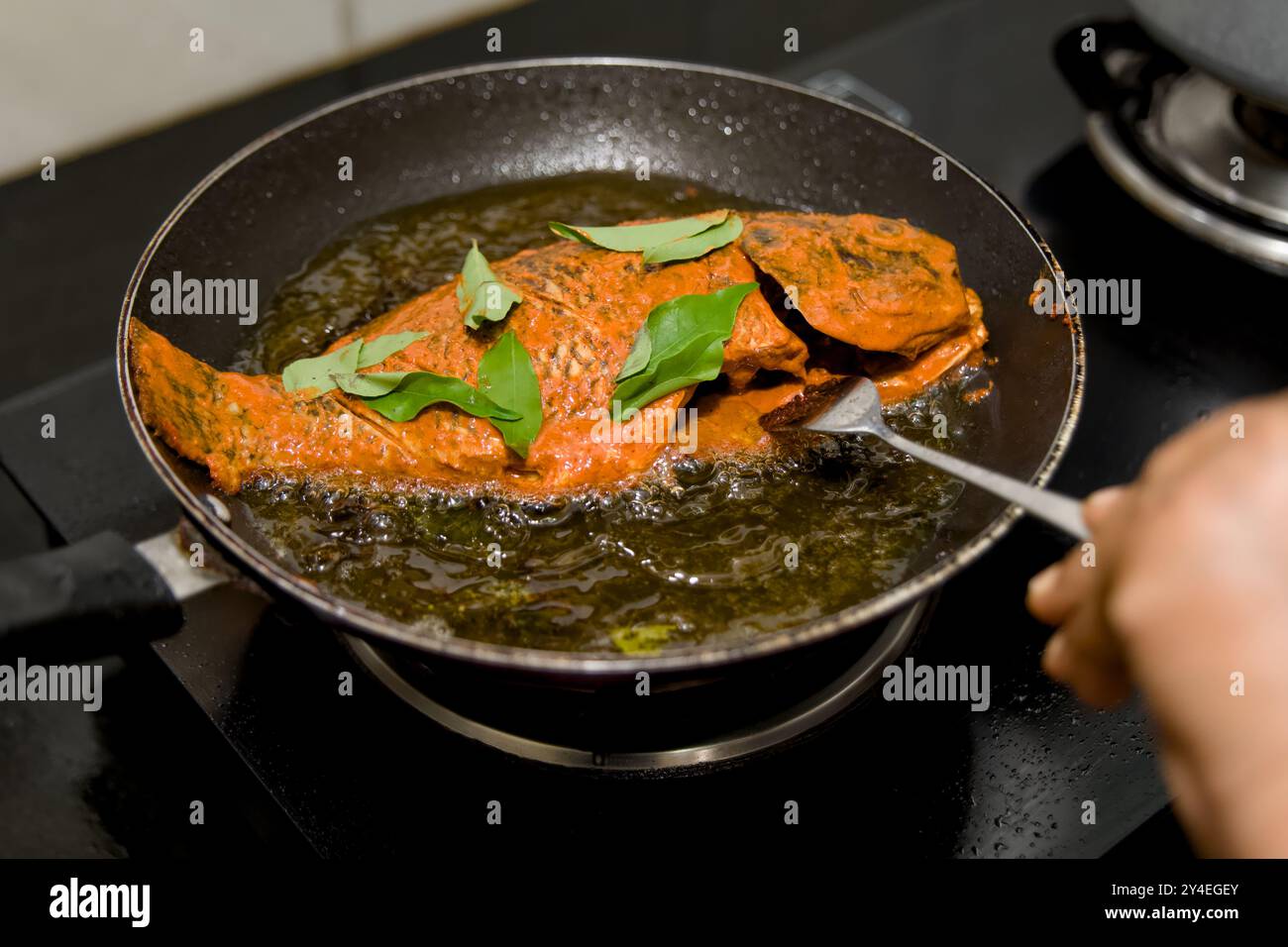 Frittura di pesce aromatico speziato alla perfezione in olio caldo, pronto a stuzzicare le papille gustative. Foto Stock