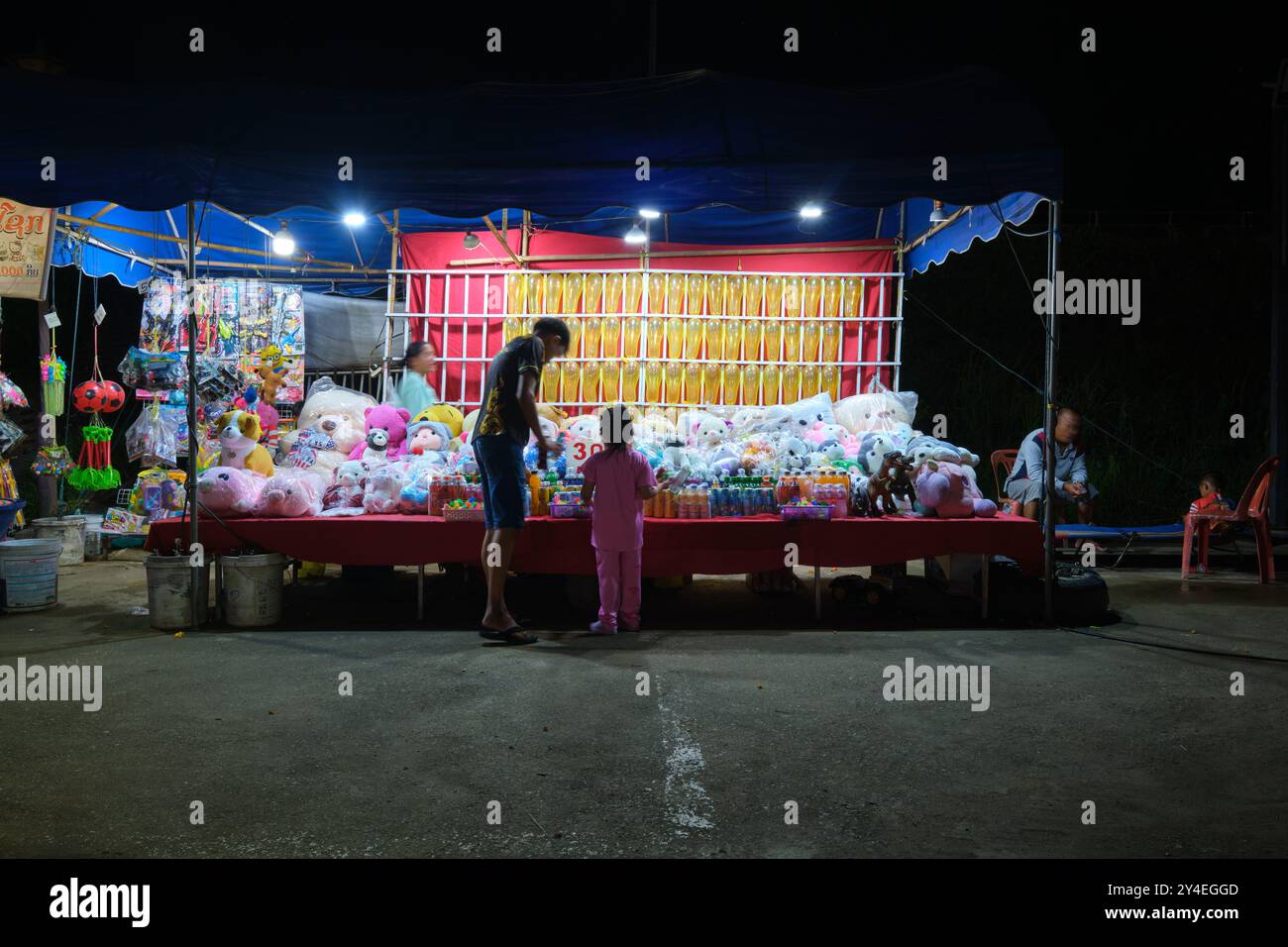 Un padre e una figlia a una partita di ballon. Al parco divertimenti sul fiume Mekong di notte a Vientiane, Laos. Foto Stock