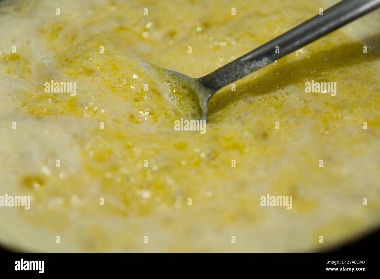Oro, bontà bollicina! Primo piano del ghee che si scioglie, perfetto per progetti di cucina e cibo. Foto Stock