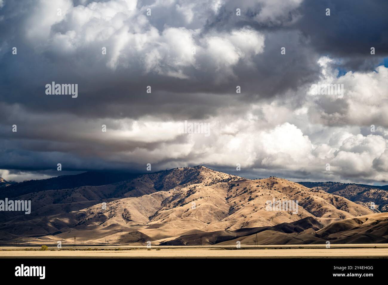 Paesaggio agricolo con terreno agricolo con campi arati e colline in pendenza prati con anfratti in una valle sullo sfondo di fitte nuvole con Foto Stock