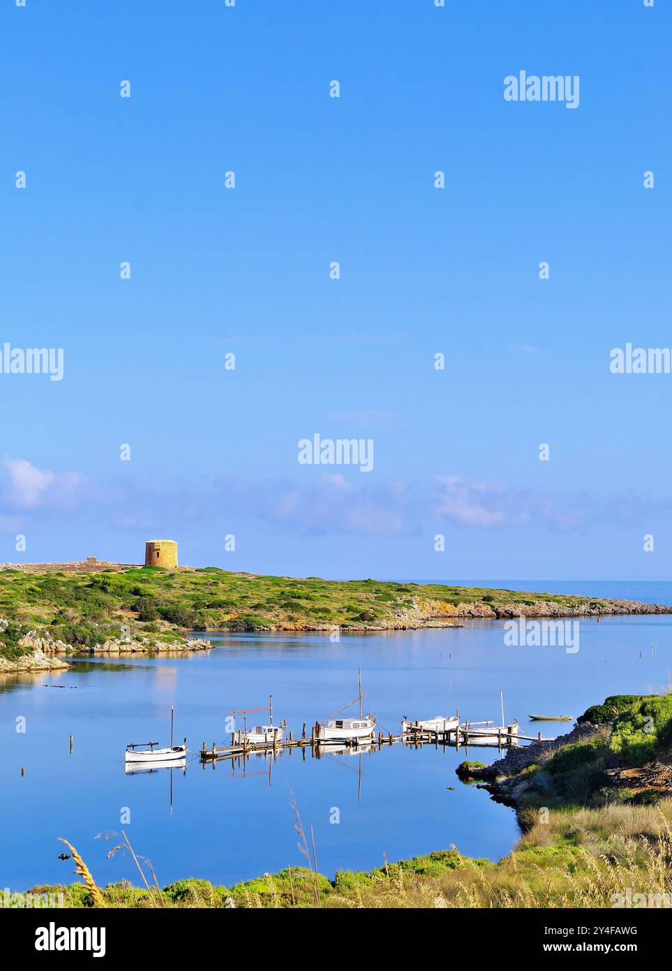 Spagna, Isole Baleari, Minorca, Cap de Cavalleria: Il piccolo porto di Sanitja con la Torre Sanitja nel bacino Foto Stock