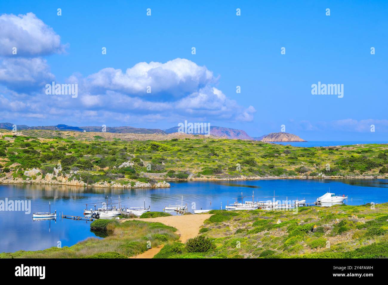 Spagna, Isole Baleari, Minorca, Cap de Cavalleria: Il piccolo porto di Sanitja con la Torre Sanitja nel bacino Foto Stock