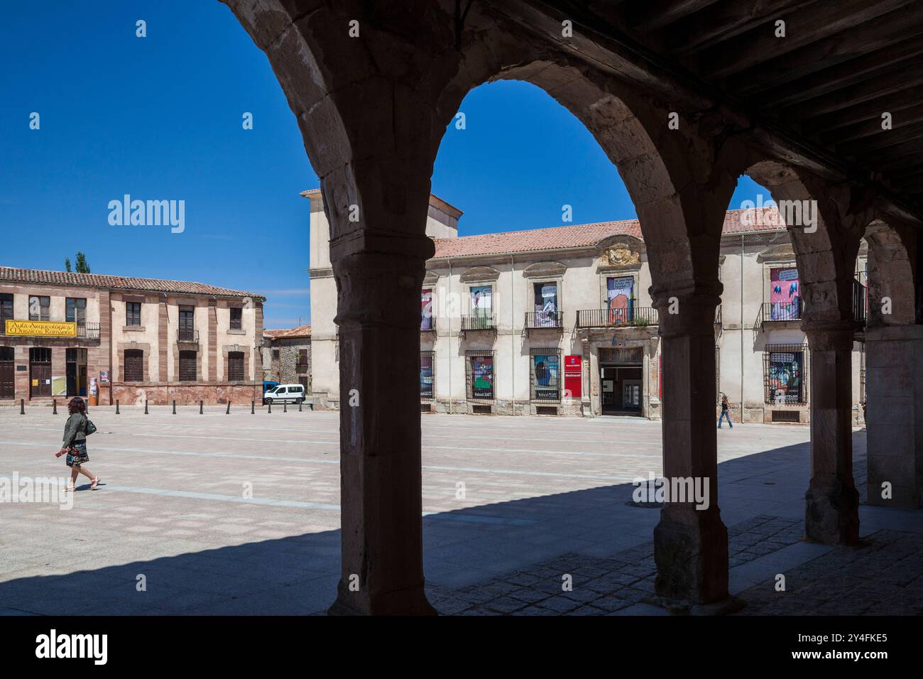 I visitatori passeggiano attraverso la piazza principale di Medinaceli, ammirando l'architettura del Palazzo Ducale sotto un cielo azzurro. Foto Stock
